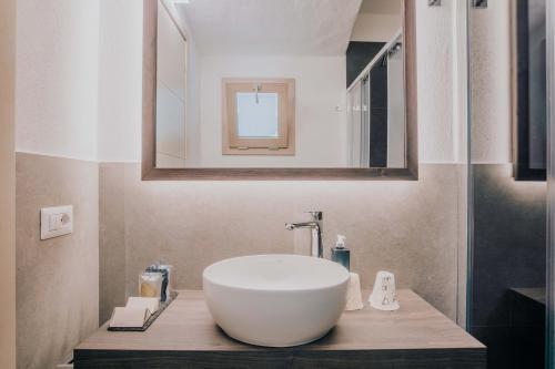 a bathroom with a large white bowl sink on a wooden counter at AMASEA Resort in San Teodoro