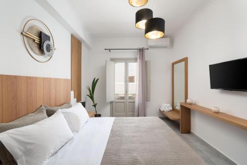 a bedroom with a bed and a flat screen tv at New Sea Serenity Villas Next to the Sea With Private Jacuzzi in Vlychada