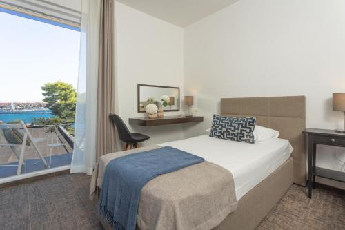 a hotel room with a bed and a balcony at Villa Arausa in Vodice