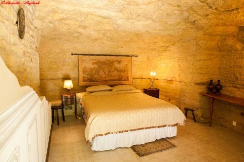 a bedroom with a bed in a stone wall at Songbird Sanctuary in Civray-de-Touraine