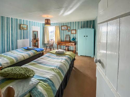 BactonにあるThe Warrenの青と白のストライプを用いた客室のベッド2台
