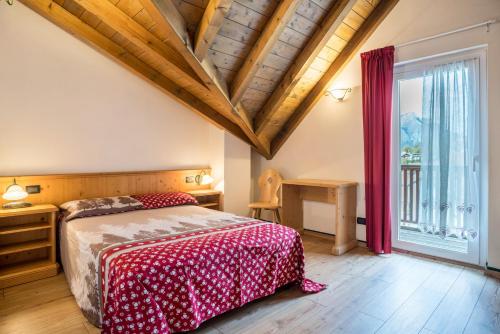 - une chambre avec un lit et une grande fenêtre dans l'établissement Giongo Residence Aparthotel 201, à Lavarone