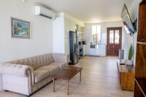 Hummingbird Oceanfront Cottage في Hauula: غرفة معيشة مع أريكة وطاولة