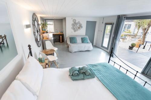 a bedroom with a white bed and a large window at The Cabin At The Beach in Seasalter