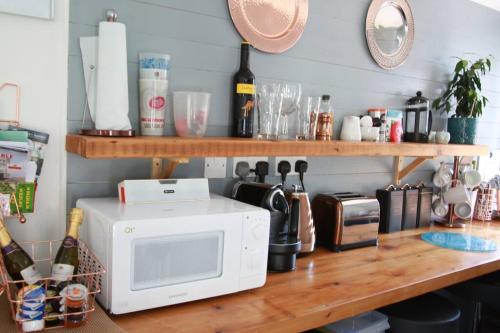 a kitchen counter with a microwave on top of it at The Cabin At The Beach in Seasalter