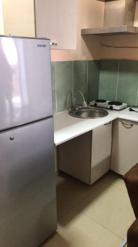 a kitchen with a white refrigerator and a sink at New Wave1 in Grigoleti