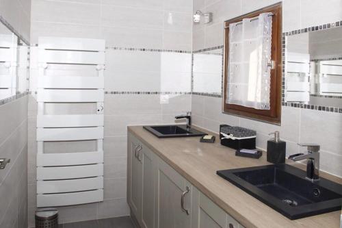 a bathroom with two sinks and a mirror at Gite les coquelicots ( classé 2* ) Duplex in LʼIsle-sur-la-Sorgue