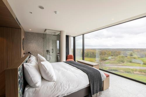 a bedroom with a bed and a large window at Van der Valk Hotel Deventer in Deventer