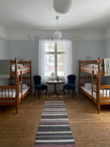 a room with bunk beds and a table and a table at Officersvillorna, Älvkarleby Vandrarhem in Älvkarleby