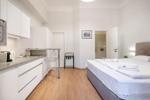een witte keuken met een groot bed in een kamer bij Klauzál Garden City Apartments- Studio K31 in Boedapest