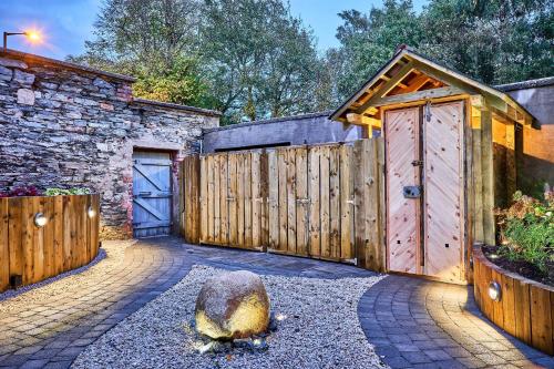 un garaje con 2 puertas de madera y un edificio de piedra en The Lawrence, en Derry Londonderry