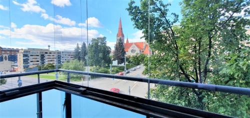 a balcony with a view of a street and a church at Kotimaailma Apartments Tampere in Tampere