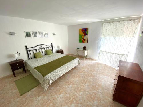 a bedroom with a large bed and a window at Casa David in Teulada
