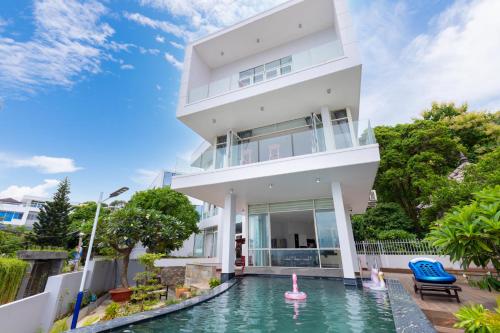 una casa blanca con piscina frente a ella en CASA DE ROSA VUNG TAU, en Vung Tau