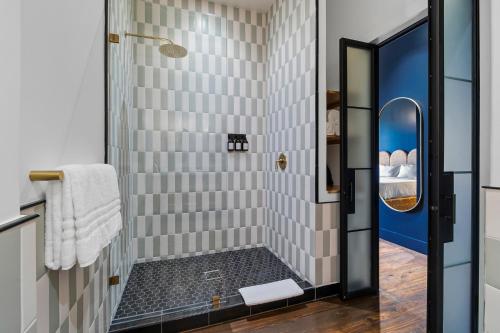 y baño con ducha de azulejos blancos. en Gruene River Inn en New Braunfels