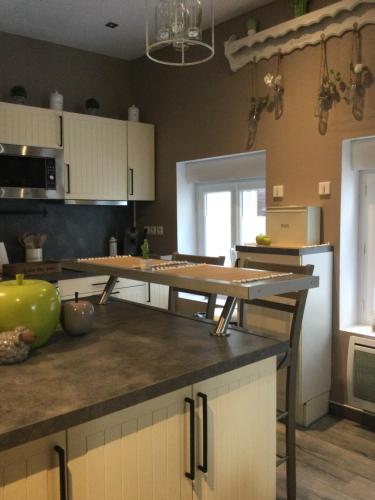 a kitchen with white cabinets and a counter top at Au p’tit nid douillet in Guînes
