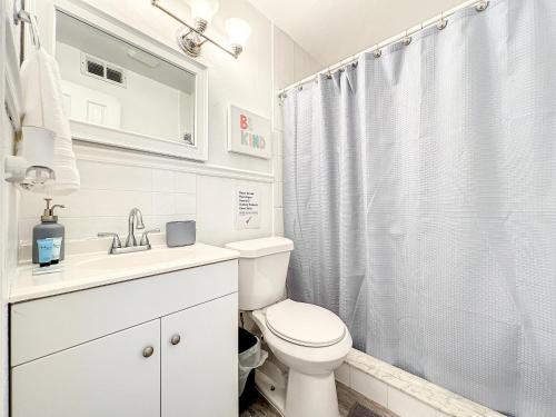 y baño blanco con aseo y ducha. en 2 Bed Alamonte Springs Apartment Unit 1, en Orlando