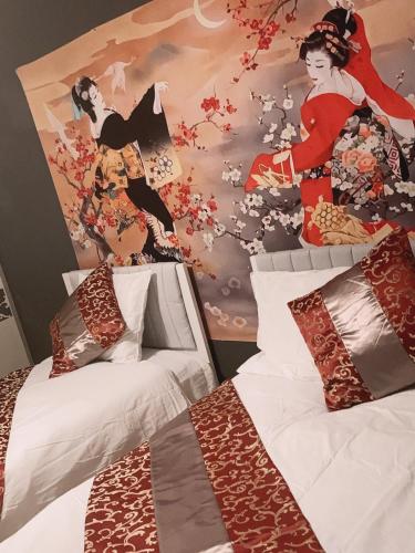 a bedroom with two beds and a wall with a mural at 美ハウス in Tokyo