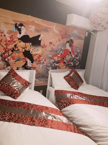 two beds in a room with a painting on the wall at 美ハウス in Tokyo