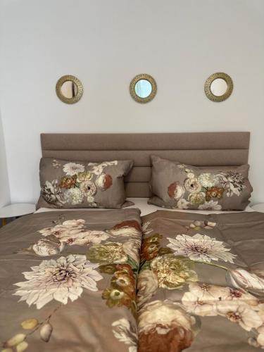 a bed with two pillows with flowers on it at Modernes Haus nähe Parndorf in Bruck an der Leitha