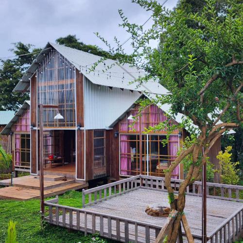 una casa con terraza y un árbol en Rumhaoy Maison, en Phumĭ Pu Pal