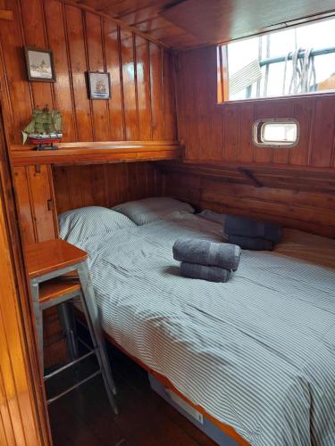 een kleine slaapkamer met een bed in een boot bij Woontjalk Bûten Ferwachting in Makkum