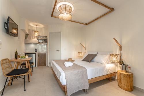 a bedroom with a bed and a table and a kitchen at Heavenly Suites & Studios in Naxos Chora