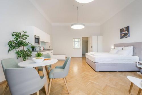 - une chambre avec un lit, une table et des chaises dans l'établissement Klauzál Garden City Apartments - deluxe studio with Balcony K23, à Budapest