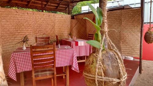 un restaurant avec une table, des chaises et une plante dans l'établissement Leena marari beach house, à Alappuzha