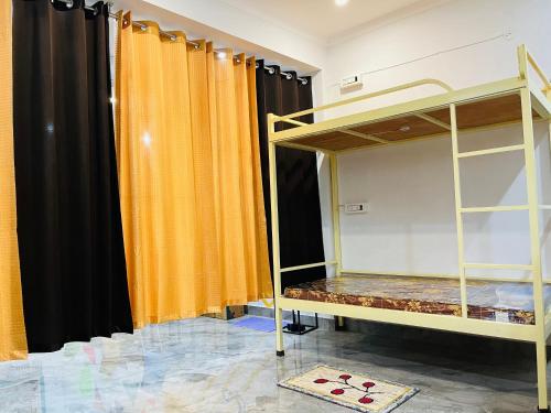 Habitación con cortinas de color naranja y litera en wuiD stayin wakeupinDoon en Dehradun