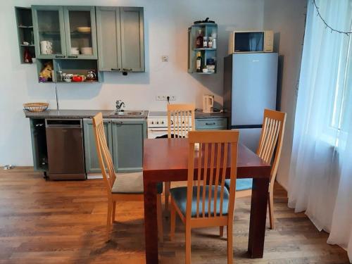 a kitchen with a table and chairs and a refrigerator at House with spacious garden and a simple sauna in Põltsamaa