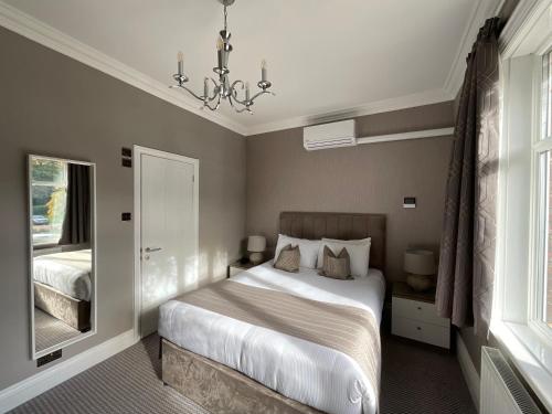a bedroom with a bed and a chandelier at The Riverside in Salisbury