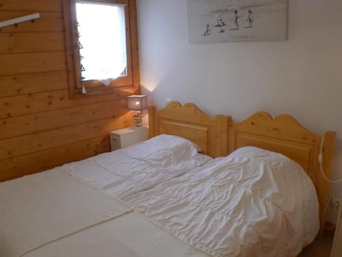 - un lit blanc dans une chambre avec fenêtre dans l'établissement Cosy appartement 3 pièces au centre - parking et animaux admis - FR-1-629-89, à Samoëns