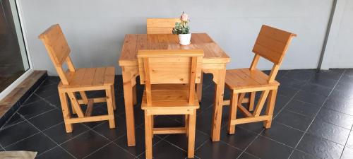uma mesa de madeira e duas cadeiras e uma mesa com uma planta em โฮมสเตย์แม่ปราณี3 