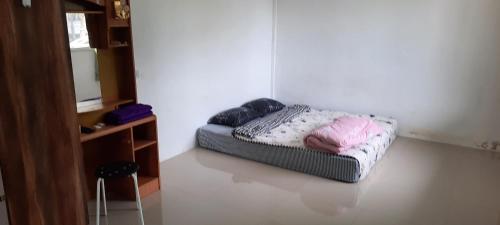 een bed in een hoek van een kamer bij โฮมสเตย์แม่ปราณี3 
