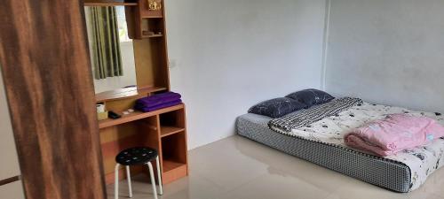 een kleine slaapkamer met een bed en een spiegel bij โฮมสเตย์แม่ปราณี3 