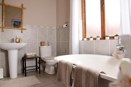 ein Badezimmer mit einer Badewanne, einem WC und einem Waschbecken in der Unterkunft Sebakwe in Dullstroom