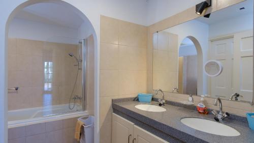 een badkamer met 2 wastafels en een grote spiegel bij Casa Curacao Ocean Resort near Mambo Beach in Willemstad