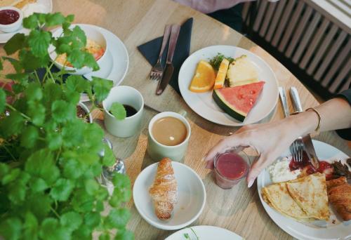 une table avec des assiettes de nourriture et une personne prenant un morceau de pain dans l'établissement Comfort Hotel City, à Göteborg