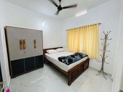 1 dormitorio con cama y ventana en Furnished 2 BHK Family Apartments near Triprayar Shree Rama Temple - Beevees Homes Thriprayar, en Thanniyam