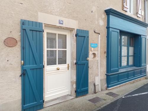 eine blaue Tür und ein Fenster auf einem Gebäude in der Unterkunft A l'école... buissonnière in Montmorillon