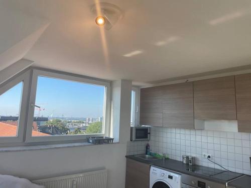 a kitchen with a window and a sink and a dishwasher at Über den Dächern von Essen in Essen