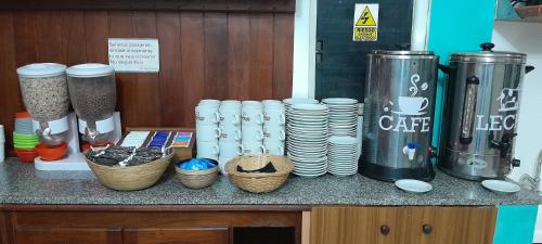 a counter with a bunch of cups and plates at HOTEL DIAMANTE in Resistencia