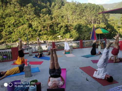 a group of people doing yoga on a deck at MOHAN GANGA VIEW HOMESTAY in Uttarkāshi