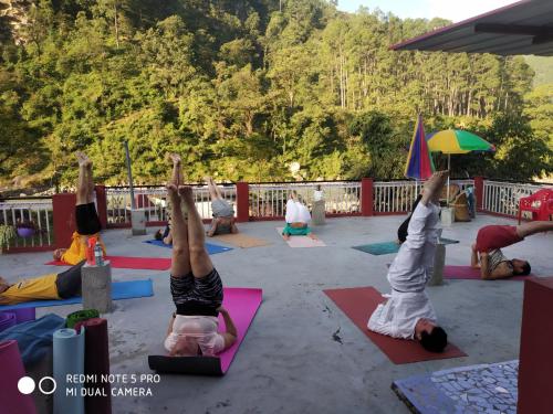 a group of people doing yoga on a patio at MOHAN GANGA VIEW HOMESTAY in Uttarkāshi