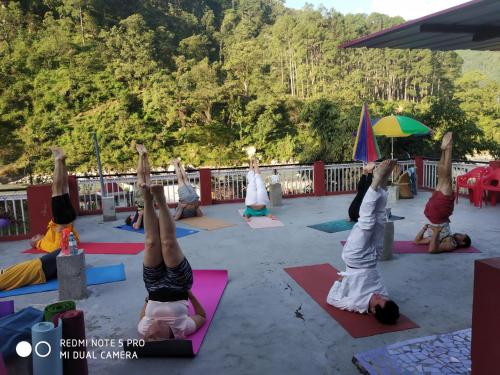 a group of people doing yoga on the beach at MOHAN GANGA VIEW HOMESTAY in Uttarkāshi