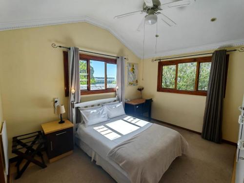 een slaapkamer met een bed en een plafondventilator bij Swiss Cottage Guest House in Kaapstad