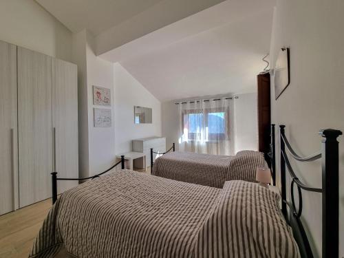 Un dormitorio con dos camas y una ventana. en Villa Rosa, en Latronico
