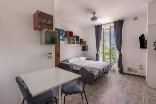a room with two beds and a table and chairs at Appartamento Campiello in Sirmione