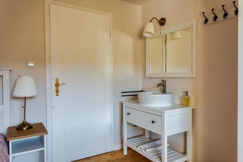 a bathroom with a white sink and a mirror at Pension Landhaus in Brombachtal